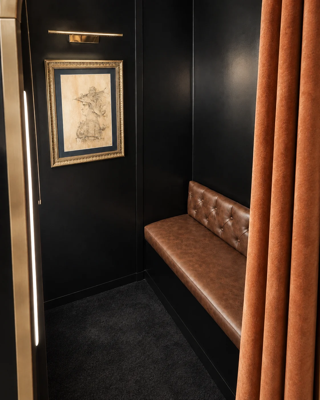 The Archive booth interior with leather seat, framed art, and curtain